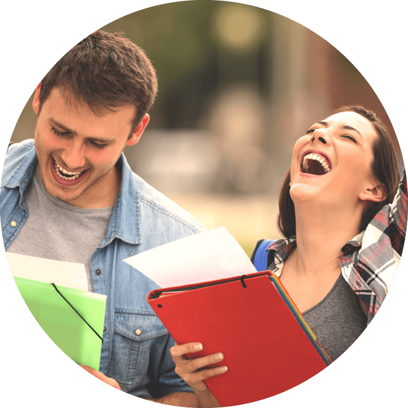 Two people are laughing while holding documents in colored folders, standing outdoors in a blurred background.